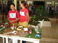 Två flickor som visar sitt skolarbete med små hus på ett bord